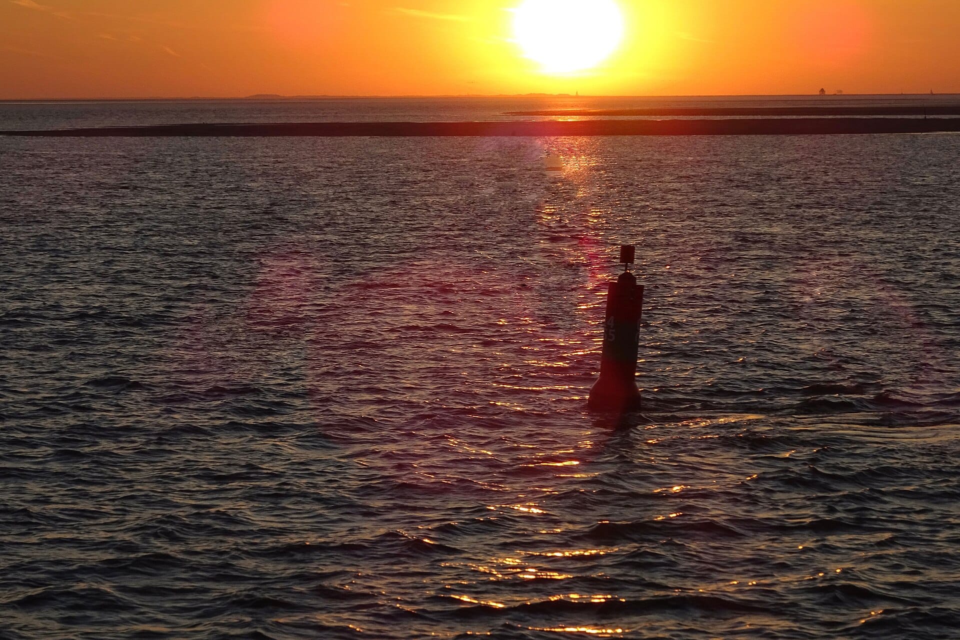 Droogvallen op de Waddenzee bij gouden zonsondergang boven een zandplaat